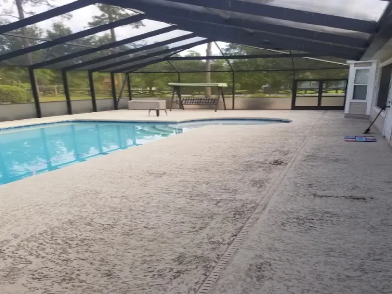 Textured pool deck darkened by algae